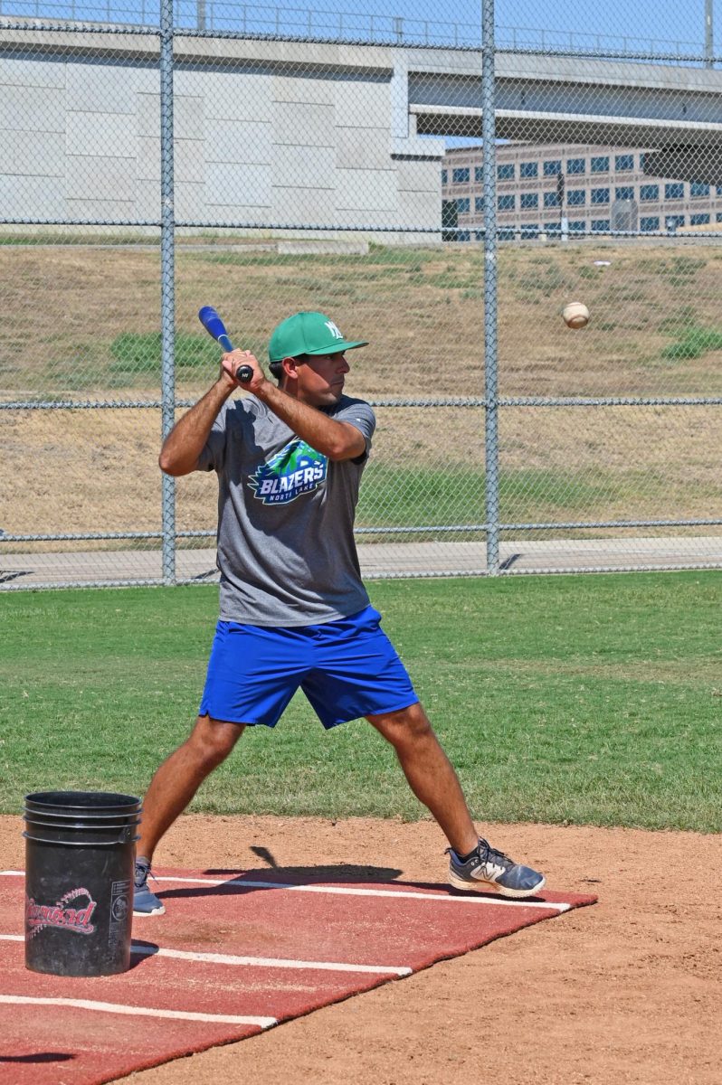 New North Lake baseball coach, Lance Fairchild demonstrates a proper batting stance during practice.  