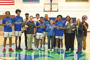 Basketball team shows off championship rings.