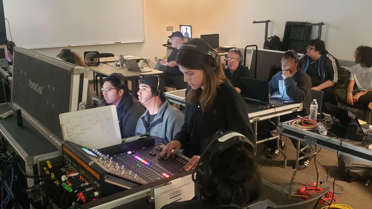 Student Javier Basilio manages the technical aspects, Chris Salinas directs, and Rebekah Gonzalez handles audio during the live sports production.