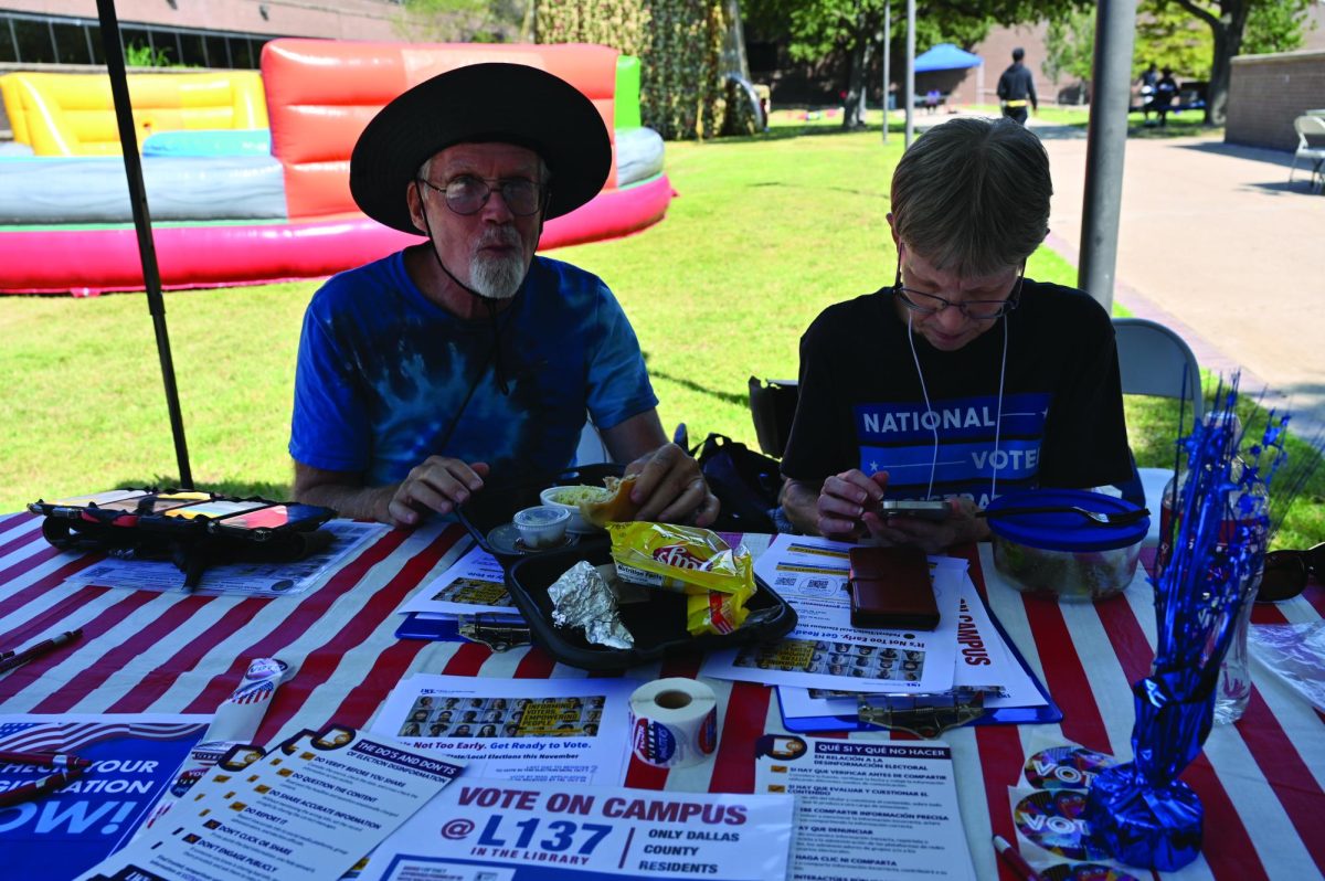 Brian Carr and Ernestine Chipman help student prepare to vote.