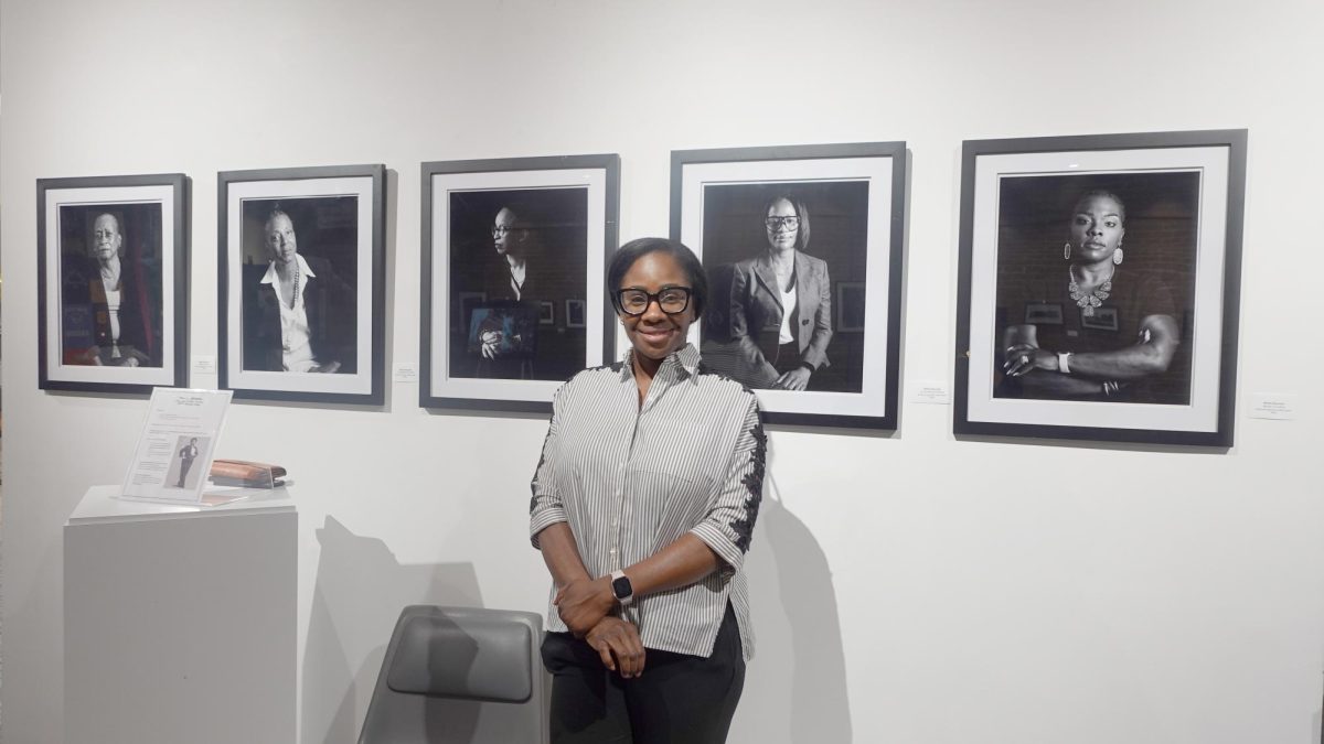 NiEtta Reynold standing infront of her photos that telling the stories of black women from South Dallas.