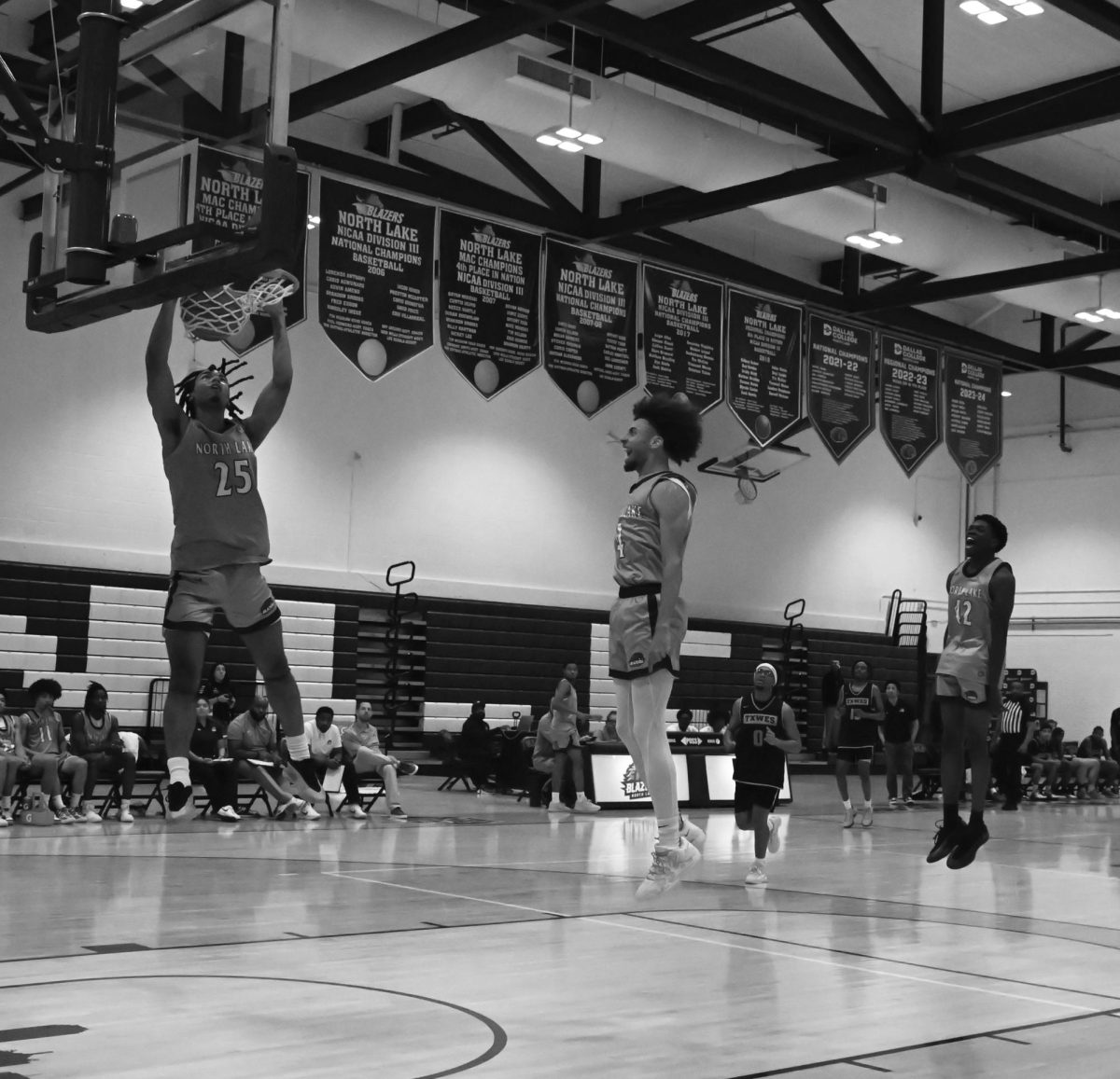 Romiel Carter finishes a dunk against Texas Wesleyan JV, drawing reactions from teammates Santana Spivey (center)
and Richard Konugah (right).