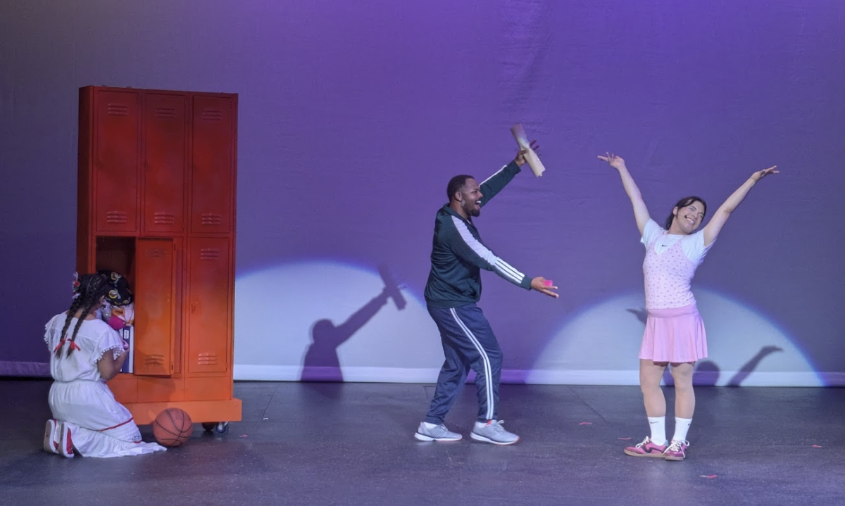 Cinderella (Nicolle Lopez) cleans a locker while Joey (Quincy Canady III) applauds Rosa
(Zini Canas) in ‘Cinderella Eats Rice and Beans.’